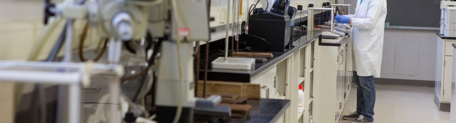 一位PG电子试玩平台的学生在科技学院的实验室里用磅秤量一种物质.