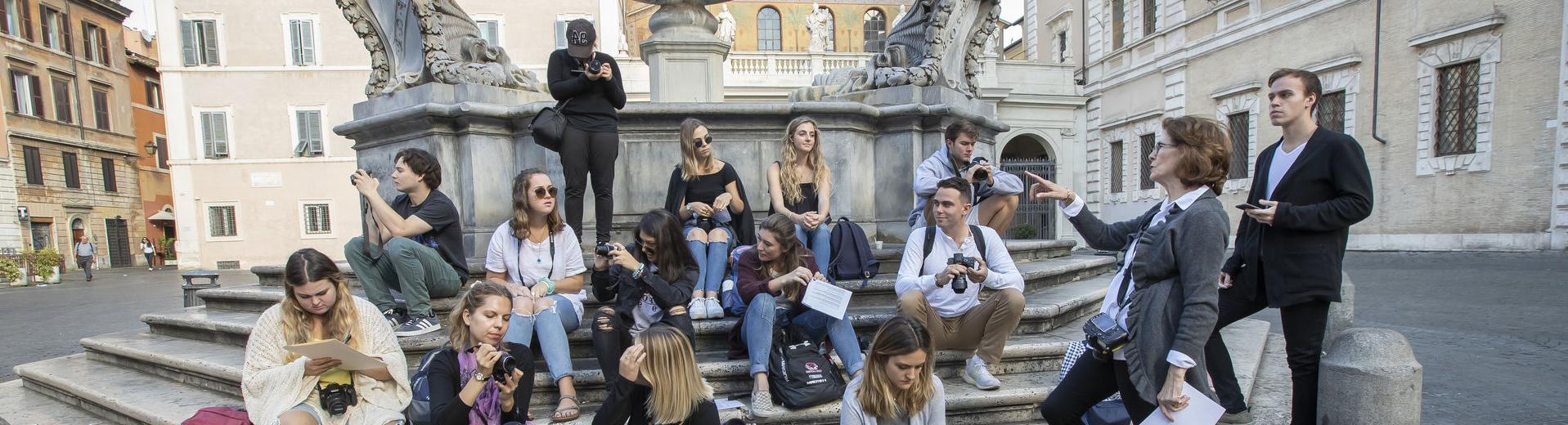 一群PG电子试玩平台APP学生聚集在意大利罗马的一个喷泉前.